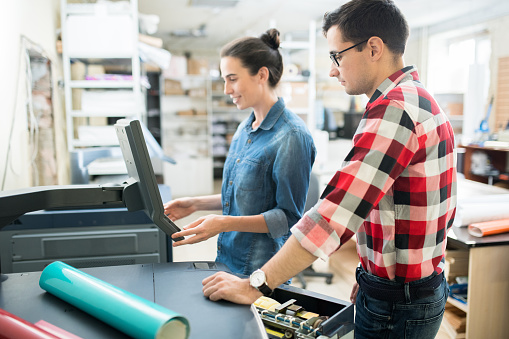 Print professionals working together at a print shop workstation